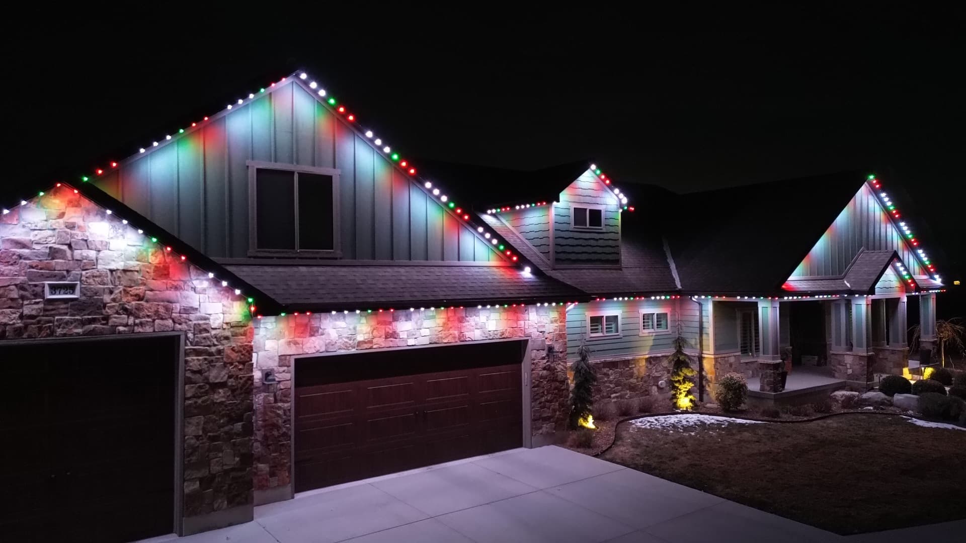 TruLight SLC permanent Christmas lights in red green and white on a luxury stone ranch home