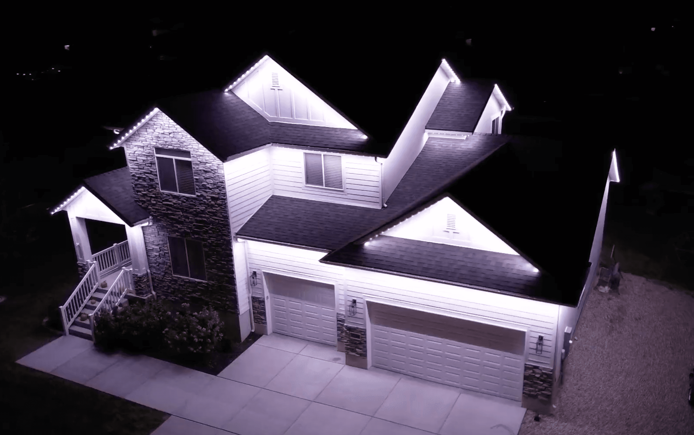 Aerial drone view of permanent LED lighting on a Bluffdale home