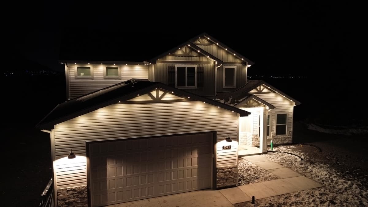 Modern farmhouse in Salt Lake City with TruLight permanent LED lighting across the roofline at night