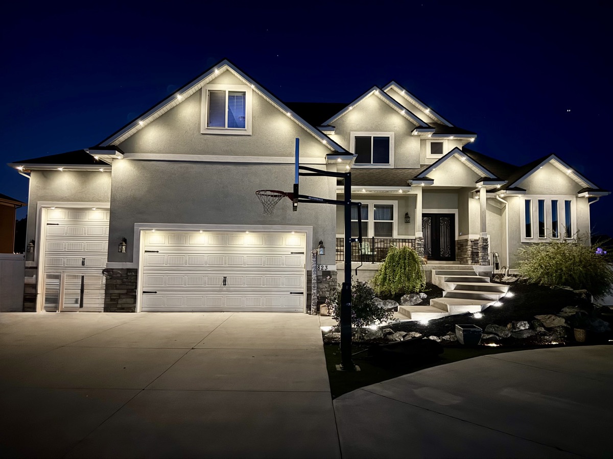 TruLight permanent lighting cleanly installed on a large stucco home in the Salt Lake Valley at dusk
